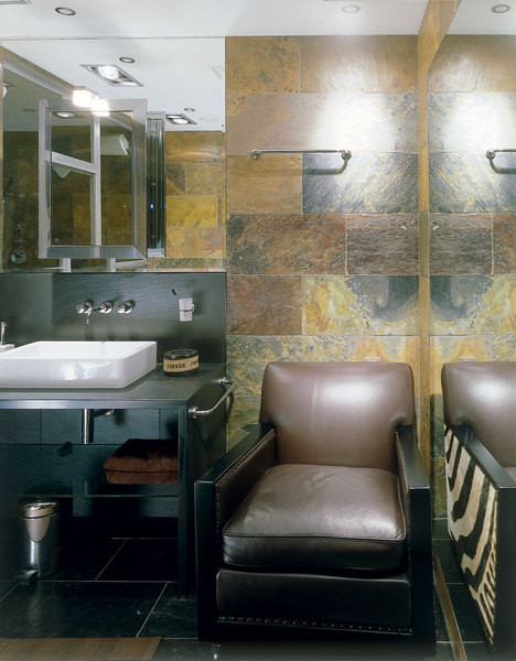 The bathroom walls are lined with African Autumn slate. Leather chair, Van Den Berg