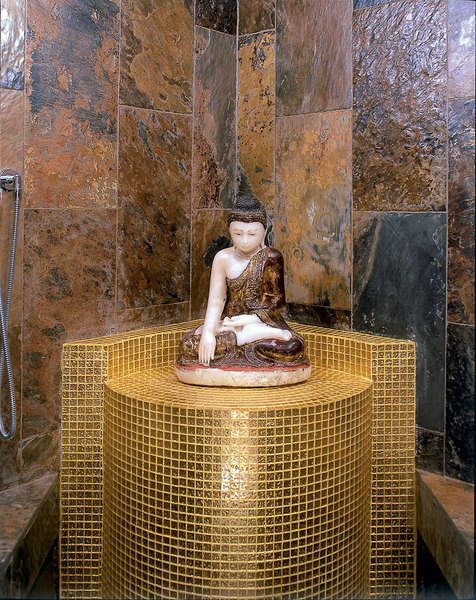 The XVIII century Buddha sits on a pedestal lined with Chinese mosaic, Golden Glass, it also trimmed the ceiling