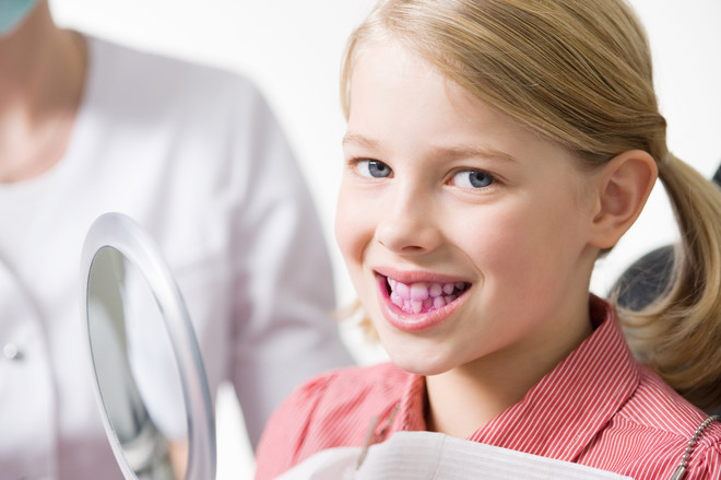 weiße Flecken auf den Zähnen eines Kindes