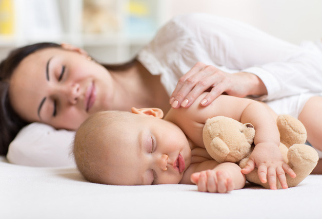 Das Baby schläft im Bett der Eltern. Womit droht es?